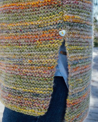 strikkepakken camelona i fabel og kidsilk erle. Her ser man splitten på genseren hvor det er isydd en knpp over.